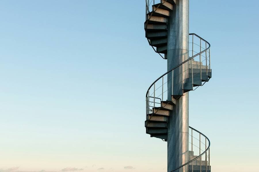 An outdoor black spiral staircase against the sky